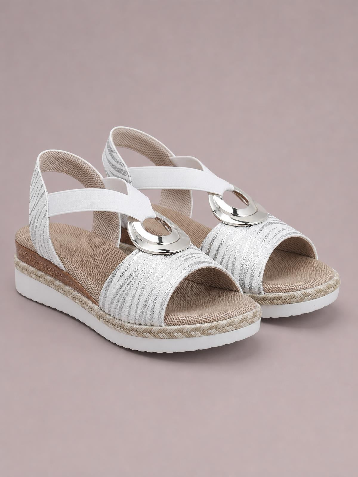 White peep toe wedge sandals with textured patterned straps, silver ring accents, braided trim, cushioned footbeds, and mid-height wedge soles.