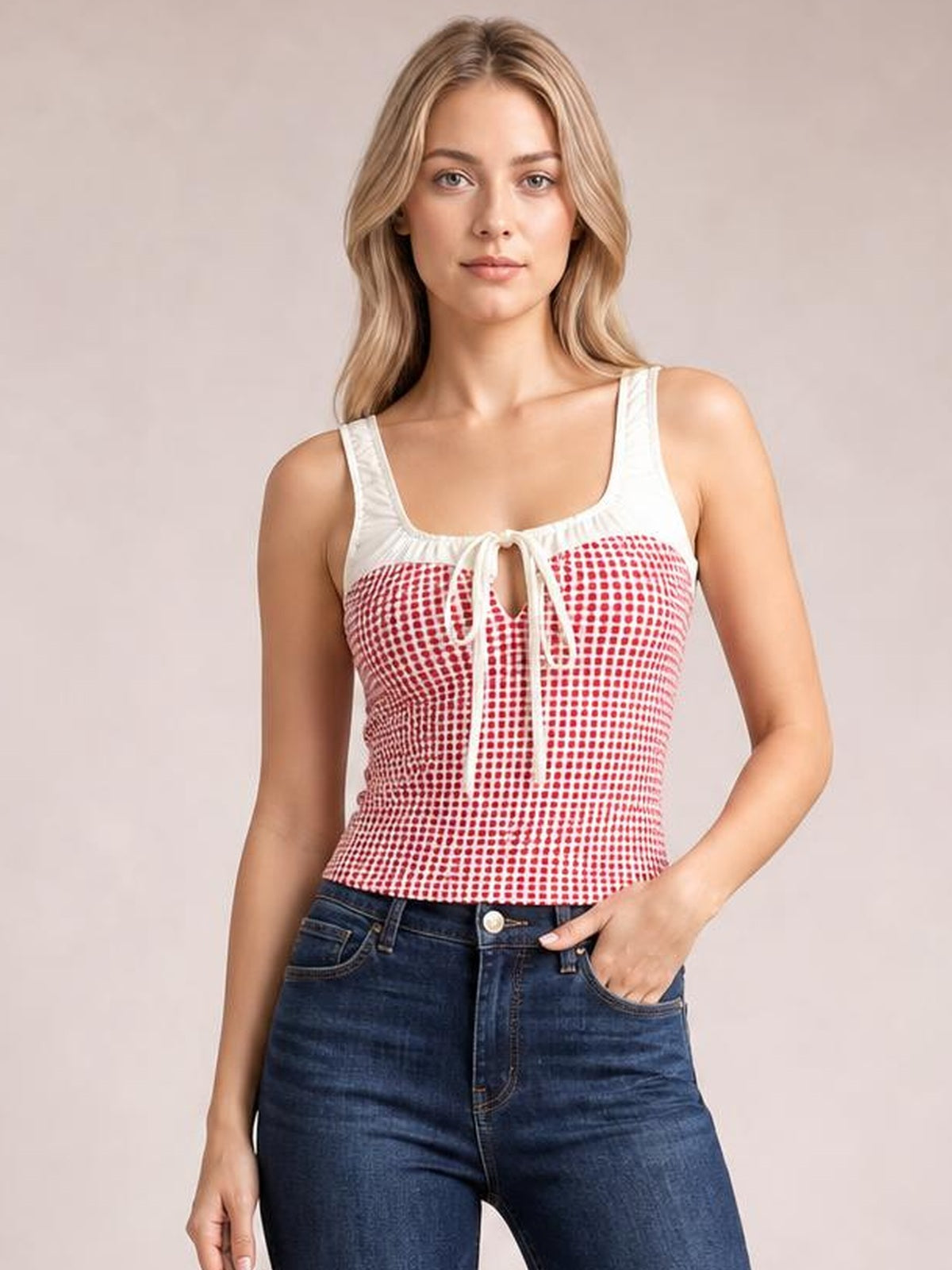 Model wears a fitted red-and-white contrast plaid square neck tank with wide straps, a front tie detail, and a waist-length silhouette.