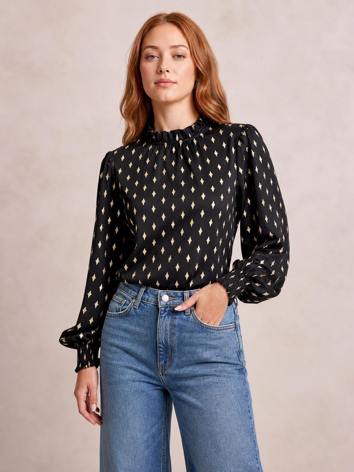 Model poses in a black geometric print blouse with a smocked frill neck, regular silhouette, and long puff lantern sleeves with gathered cuffs.