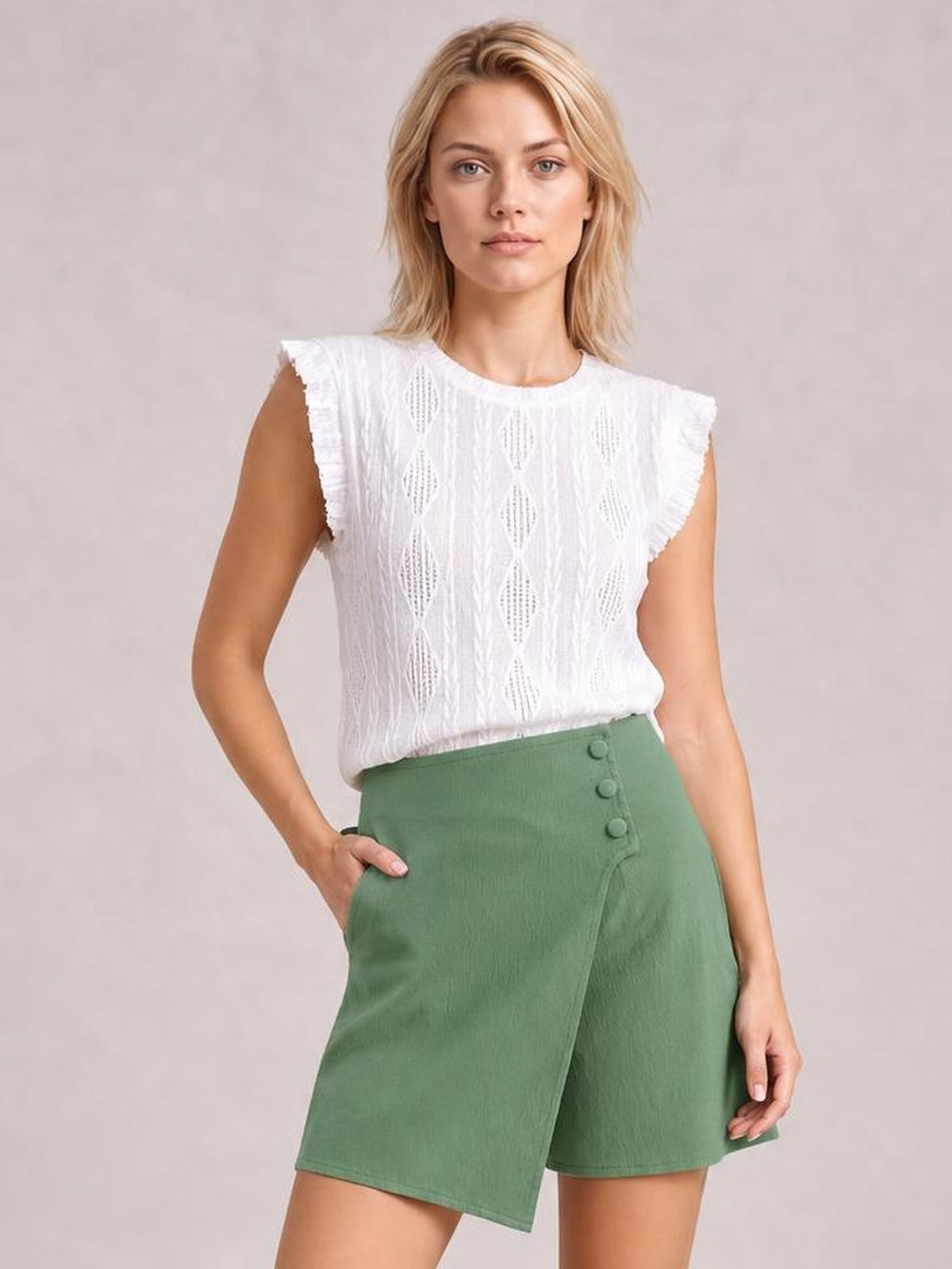 Model wears a green high-waist skort with an asymmetric wrap-front overlay, button details, side pockets, and a relaxed A-line silhouette.