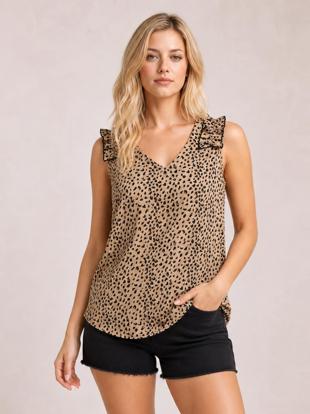 Model wearing a tan leopard-print sleeveless tank with a V-neck, ruffled shoulder trim, relaxed regular-length silhouette, and curved hem.