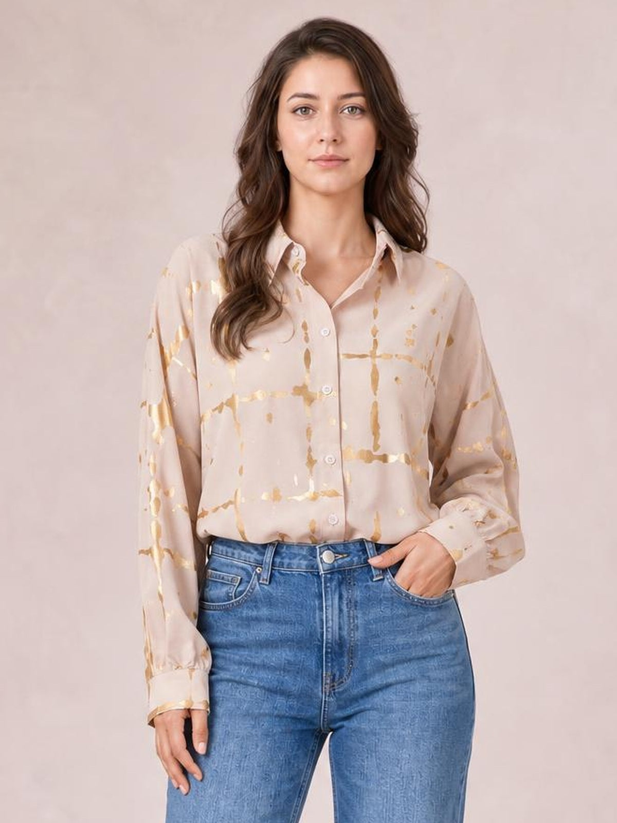 Model wears a beige printed collared neck long sleeve shirt with gold abstract lines, button-front construction, and a relaxed silhouette.
