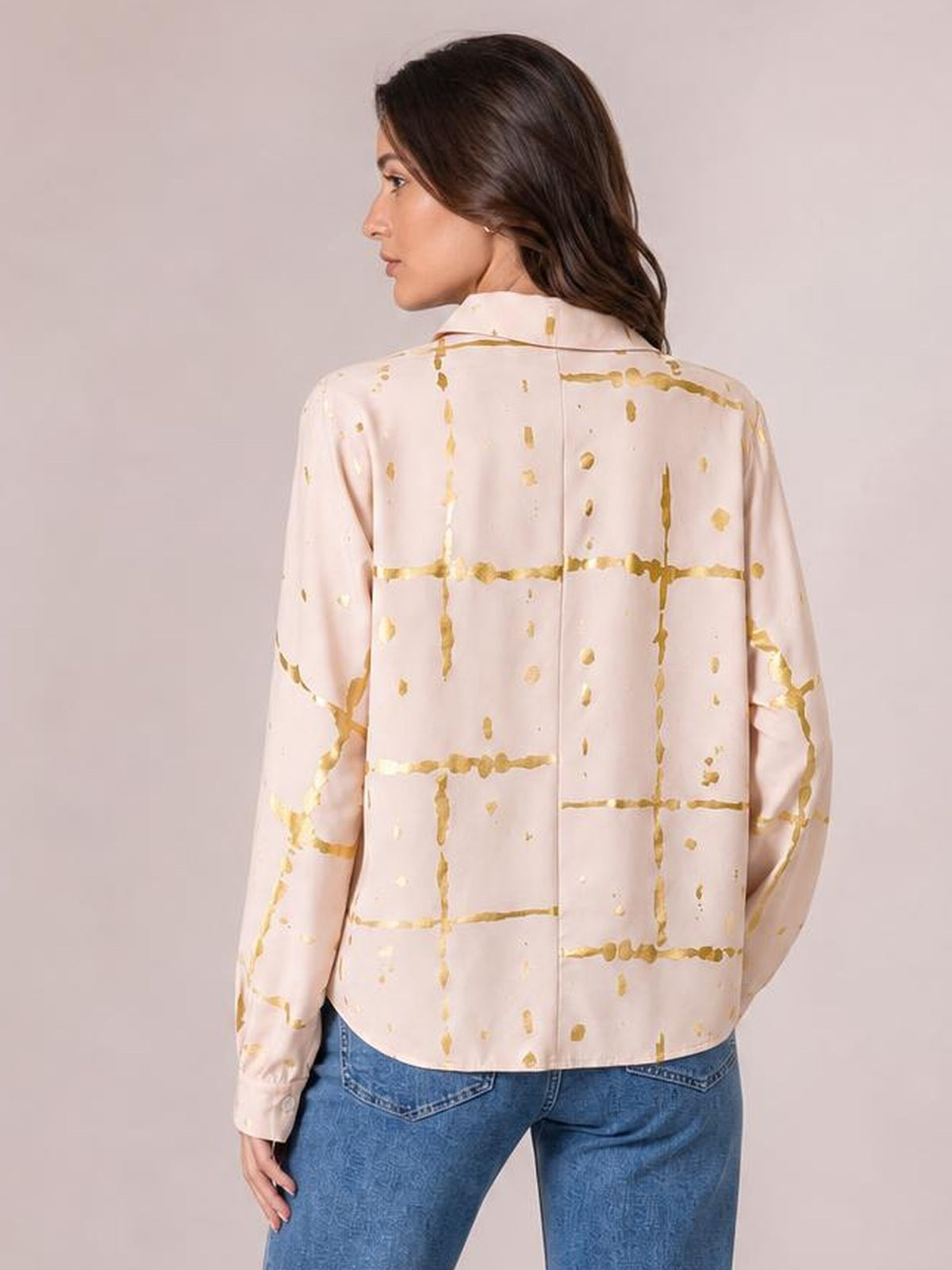 Model shown from the back wears a pale pink printed collared neck long sleeve shirt with gold grid detailing and a relaxed straight silhouette.