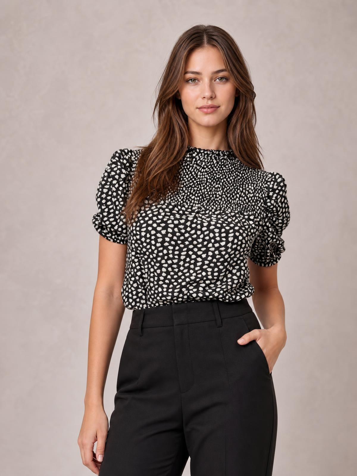 Model wearing a black-and-white printed round neck blouse with short puff sleeves, a softly gathered neckline, and a relaxed long silhouette tucked into tailored trousers.
