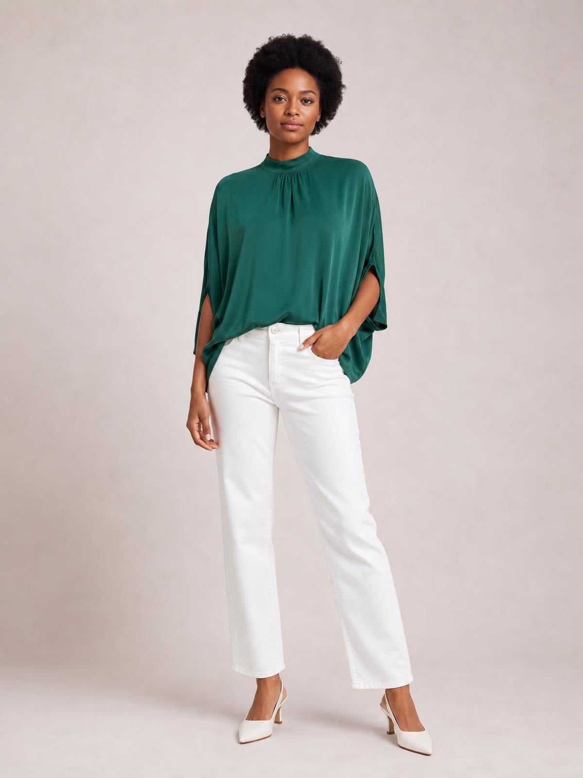 Model poses in a deep green tie-back mock neck blouse with ruched neckline, flowing relaxed silhouette, and split three-quarter sleeves.