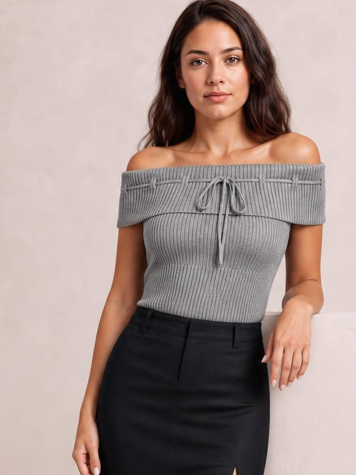 Model wearing a gray tied off-shoulder short sleeve knit top with a ribbed fitted silhouette and front tie detail.