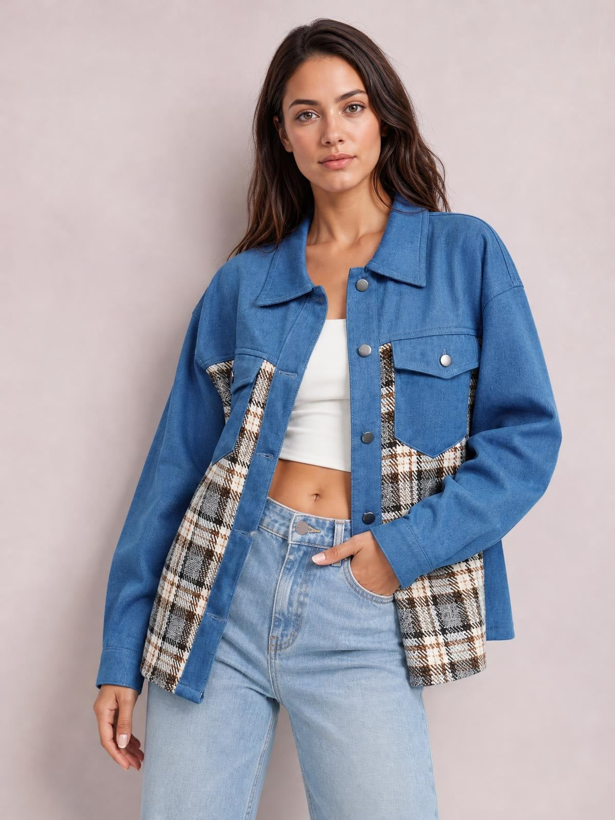 Model wears a blue denim button-up jacket with long sleeves, plaid side panels, a pointed collar, flap pockets, and a relaxed silhouette.