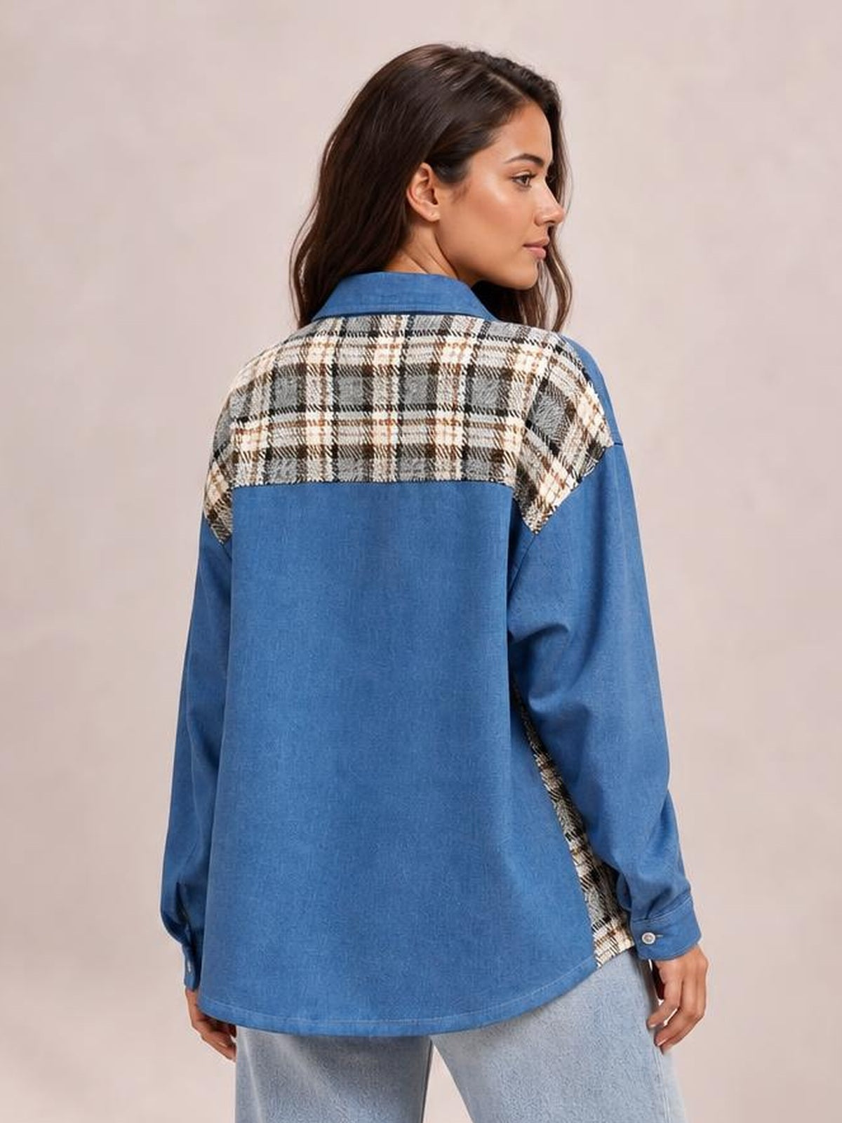 Model shown from behind wearing a relaxed blue denim jacket with long sleeves, button cuffs, and a contrasting plaid yoke and side panels.