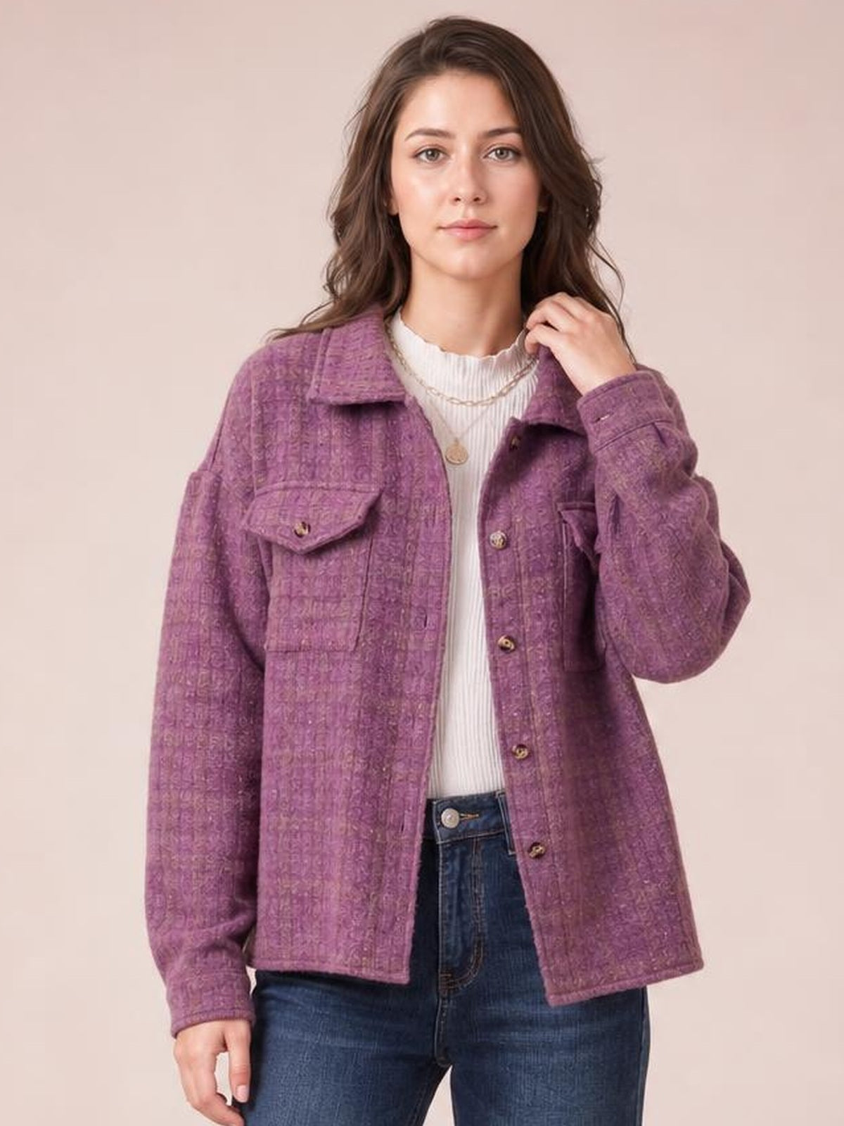 Model wears a purple plaid button-up long-sleeve jacket with a collared, relaxed silhouette, front buttons, and flap chest pockets, touching the collar.