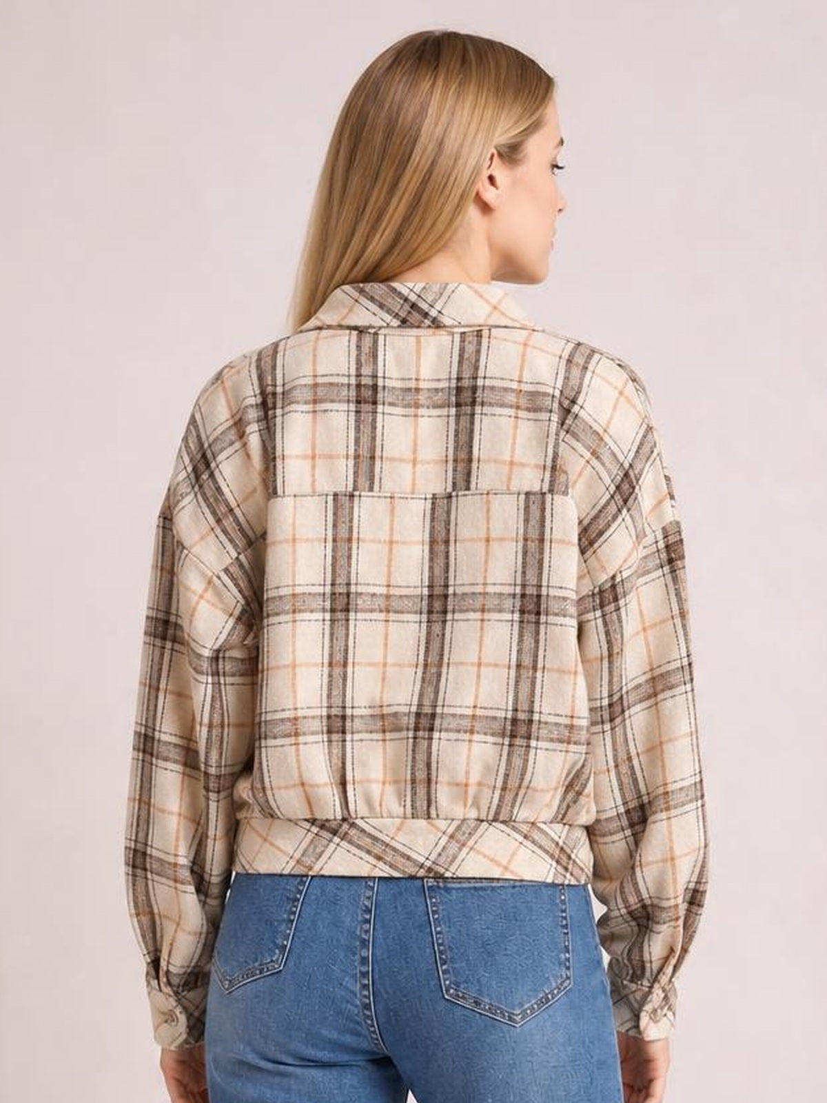 Model shown from the back wearing a beige and brown plaid button-up jacket with long sleeves, a collared neckline, and a relaxed silhouette.
