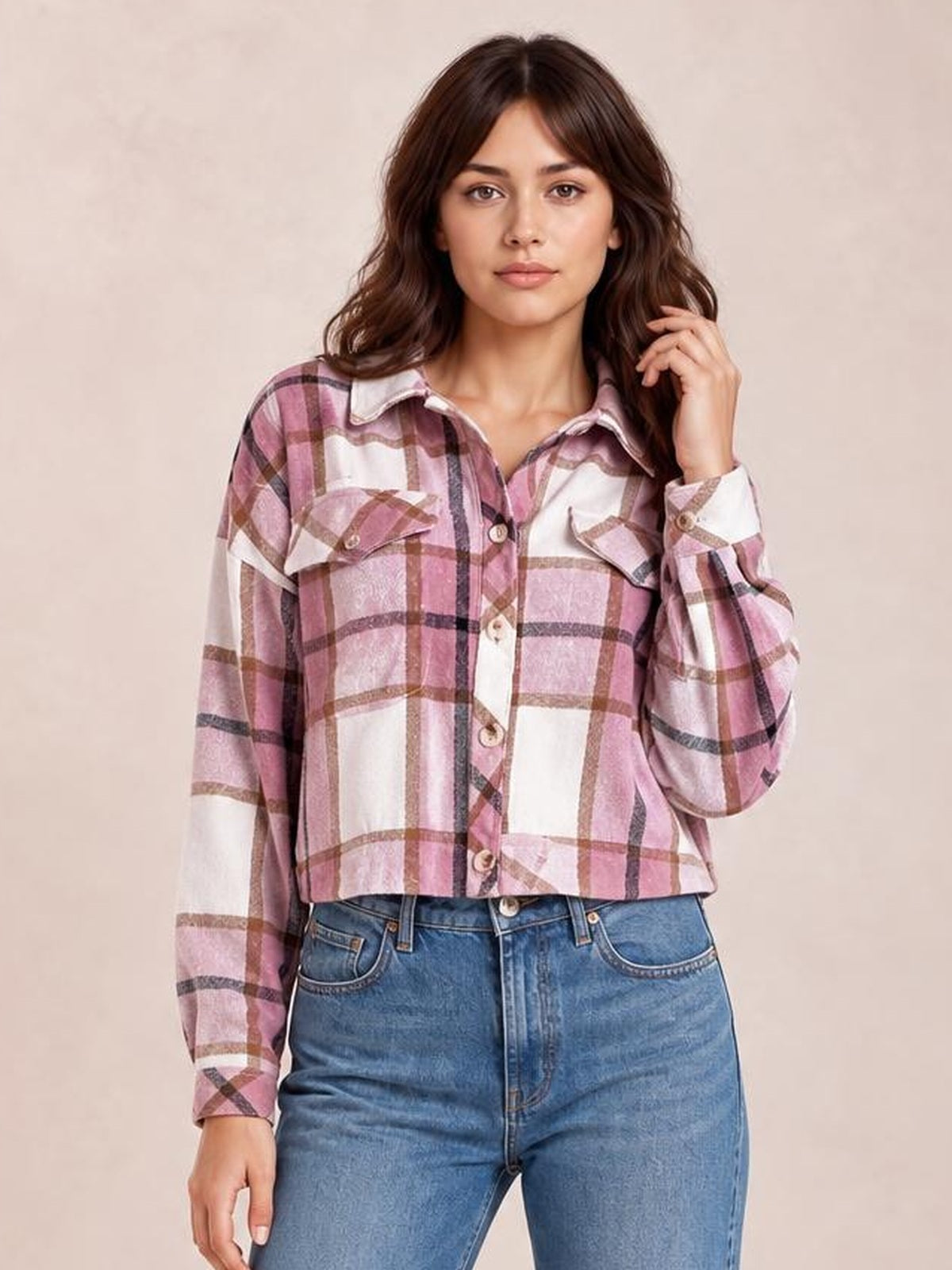 Model poses in a pink, white, and brown plaid button-up long sleeve jacket with a cropped boxy silhouette, pointed collar, and flap chest pockets.