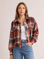 Model wears a burgundy, black, cream, and gray plaid button-up long sleeve jacket with a collared cropped silhouette and chest pockets.