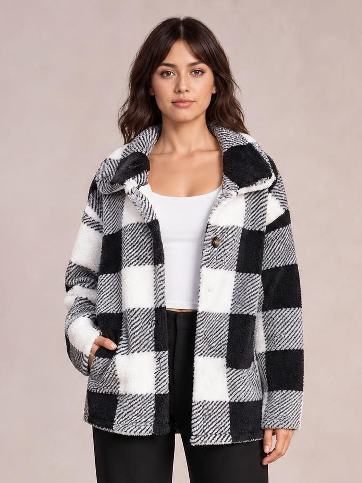 A woman stands wearing a black-and-white plaid collared button-down jacket with long sleeves, a relaxed straight silhouette, and one hand in a pocket.