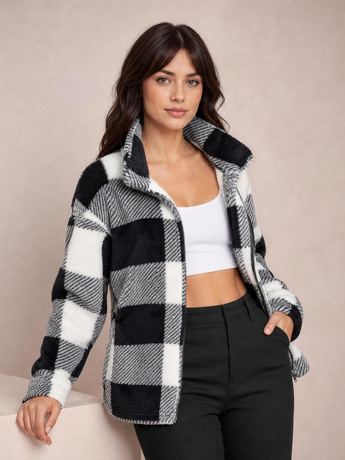 Model poses in a black-and-white plaid collared button-down jacket with long sleeves, a front zipper, and a relaxed silhouette.