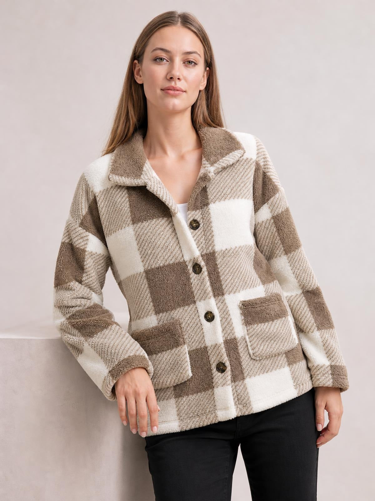 A model wears a relaxed taupe and cream plaid collared button-down jacket with long sleeves, front buttons, and two patch pockets.
