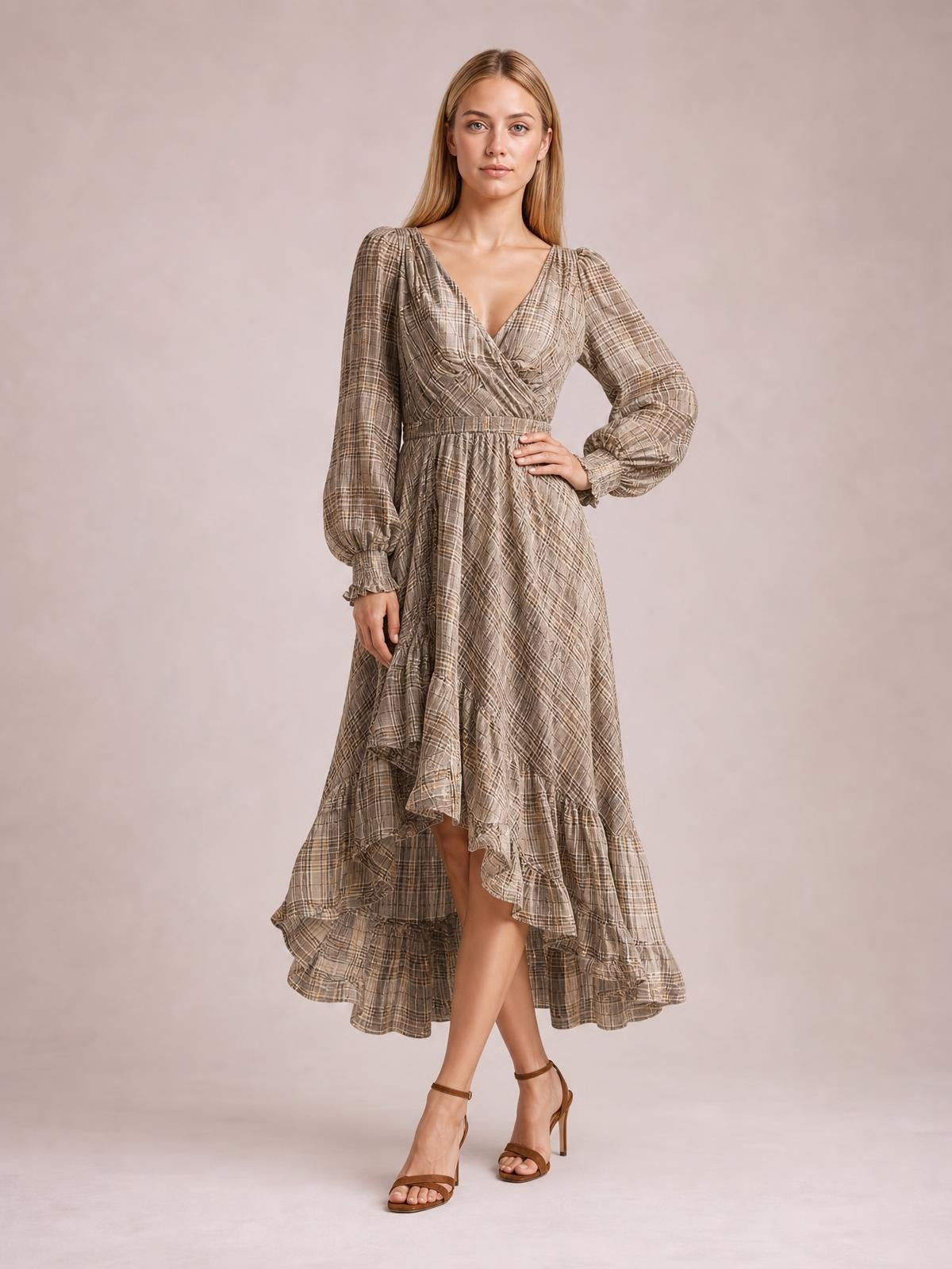 Model poses in a taupe plaid high-low dress with long sleeves, a ruffled tiered hem, V-neckline, gathered waist, and flowing silhouette.