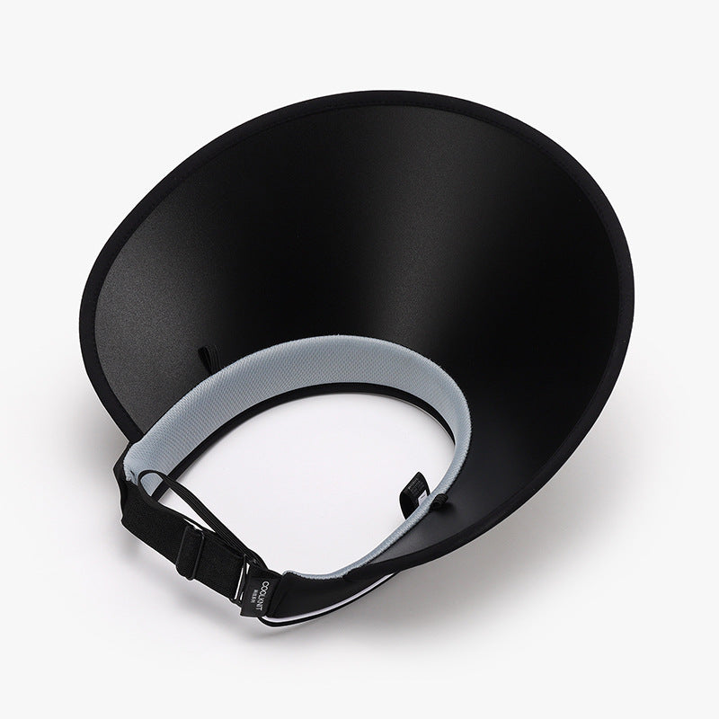 Black natural grass sun visor with a broad, gently curved brim, adjustable back fastening, and attached chin cord shown from the underside.