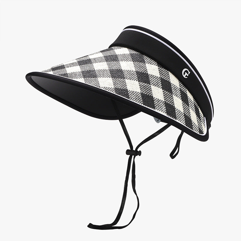 Plaid natural grass sun visor with a broad curved brim, structured black-trimmed silhouette, adjustable fastening, and attached chin cord.