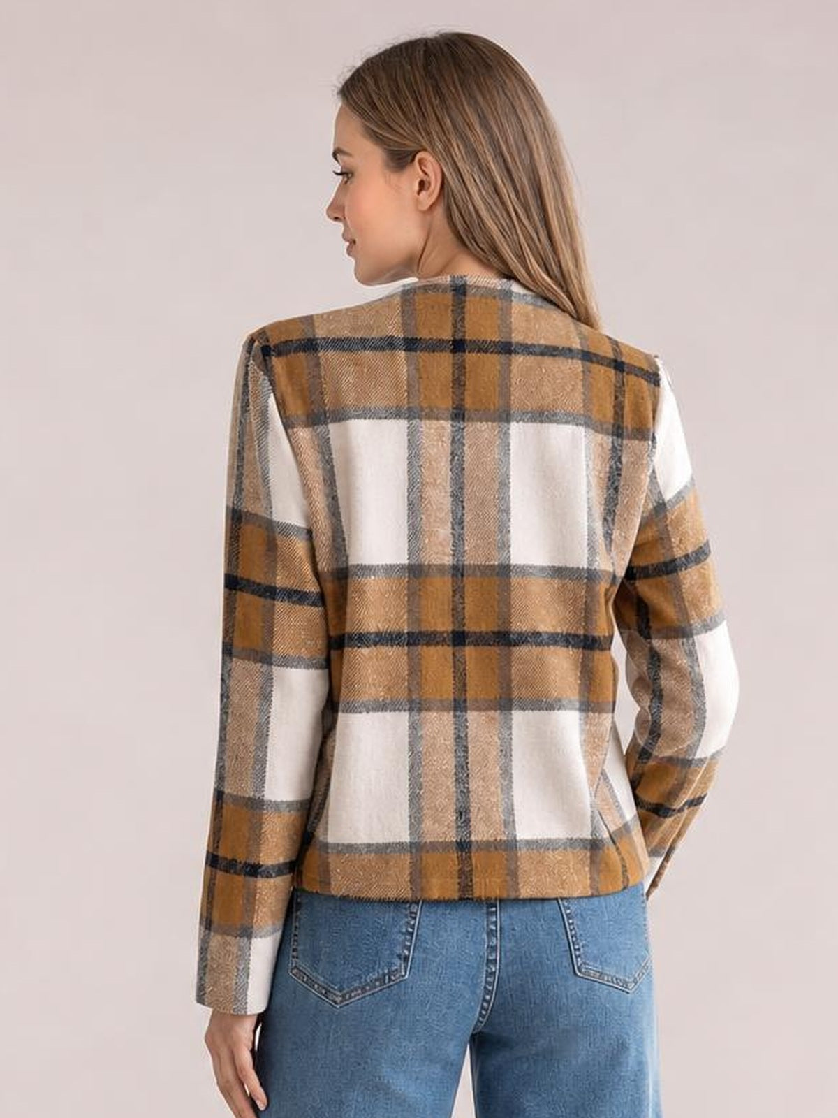 Model seen from behind wearing a tan, cream, and black plaid open-front long sleeve jacket with a straight silhouette and lined body.