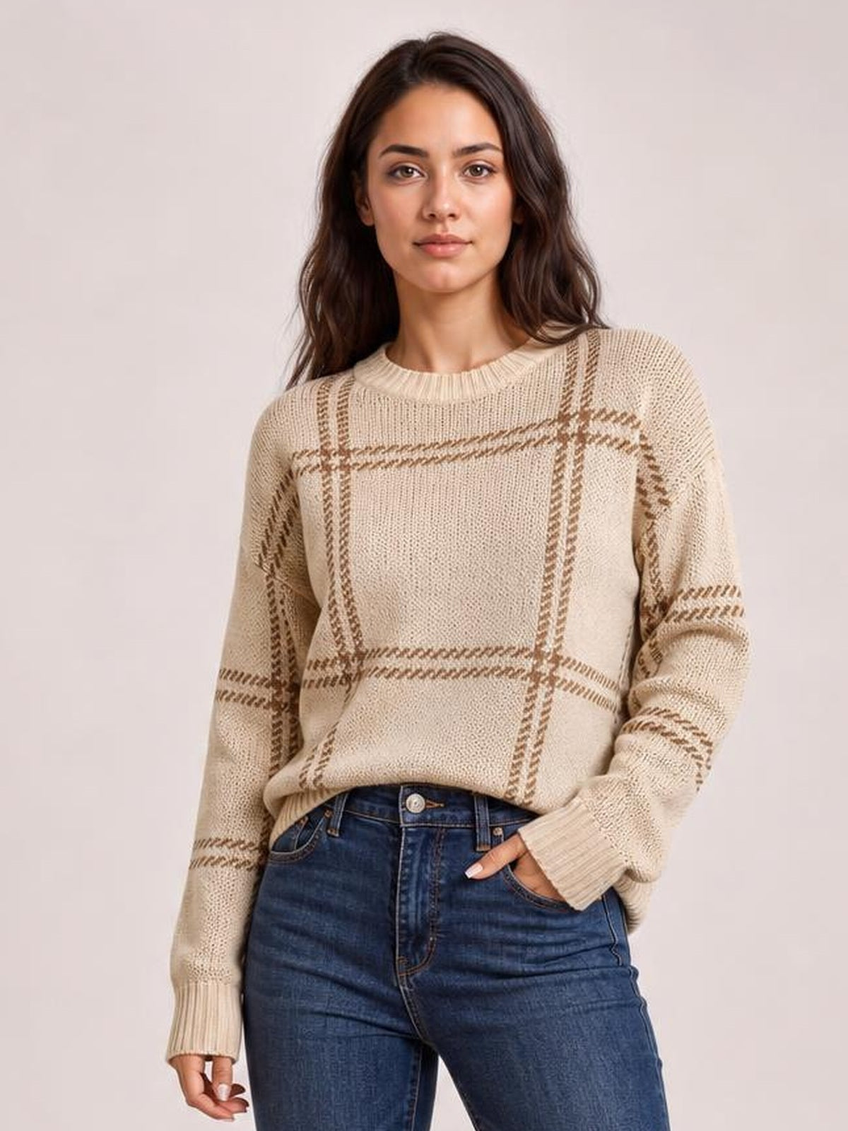 Model wearing a beige plaid round neck sweater with dropped shoulders, relaxed silhouette, long sleeves, and ribbed neckline, cuffs, and hem.