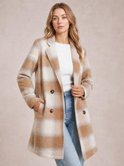 A model poses in a beige and cream plaid longline jacket with notched lapels, button closure, long sleeves, and front pockets.