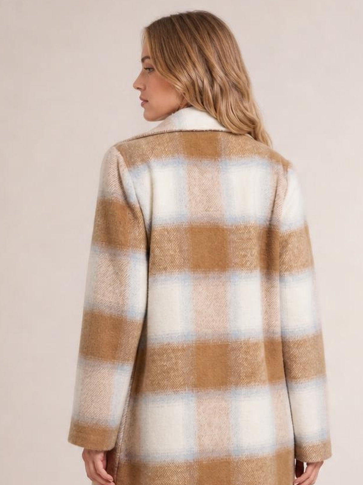 Model shown from behind wears a longline plaid jacket in tan, cream, and pale blue with a straight silhouette, long sleeves, and a contrasting white collar.