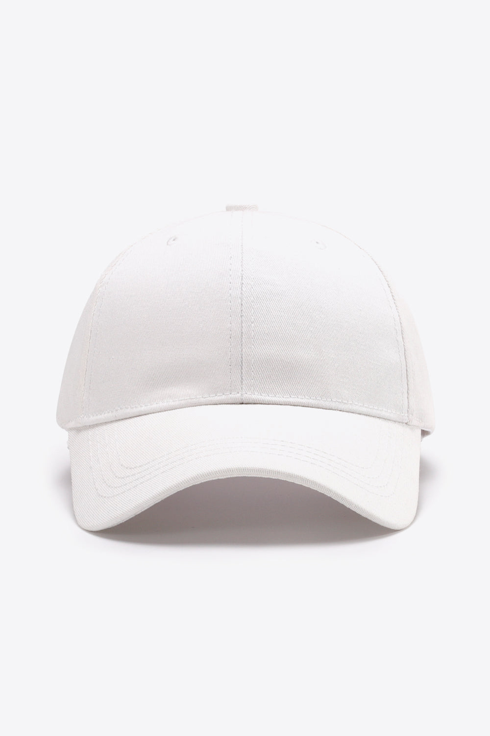 A plain white cotton baseball cap with a structured six-panel silhouette, gently curved brim, tonal stitching, and subtle ventilation eyelets.