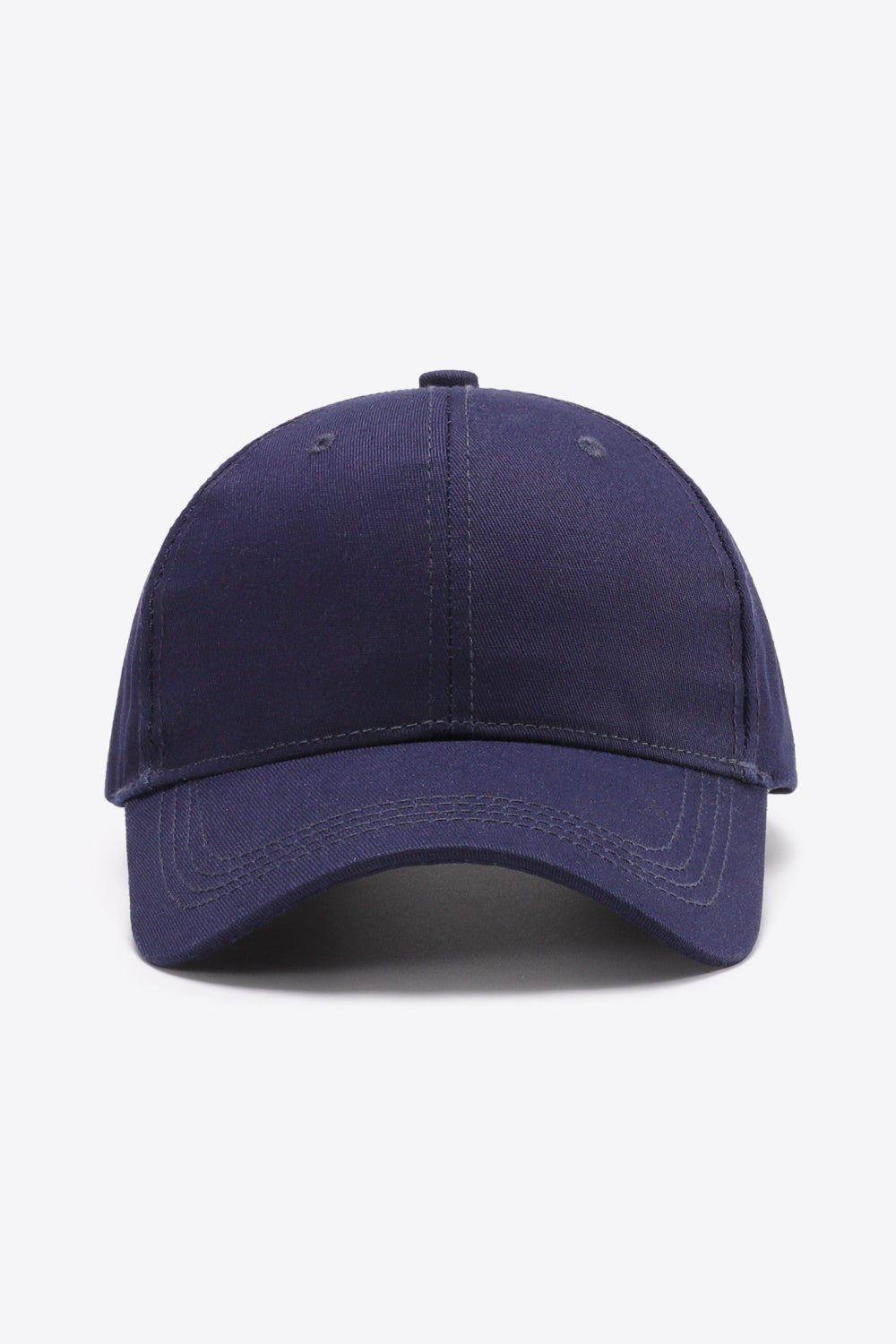 A solid navy cotton baseball cap features a structured six-panel crown, gently curved brim, tonal stitching, and small ventilation eyelets.