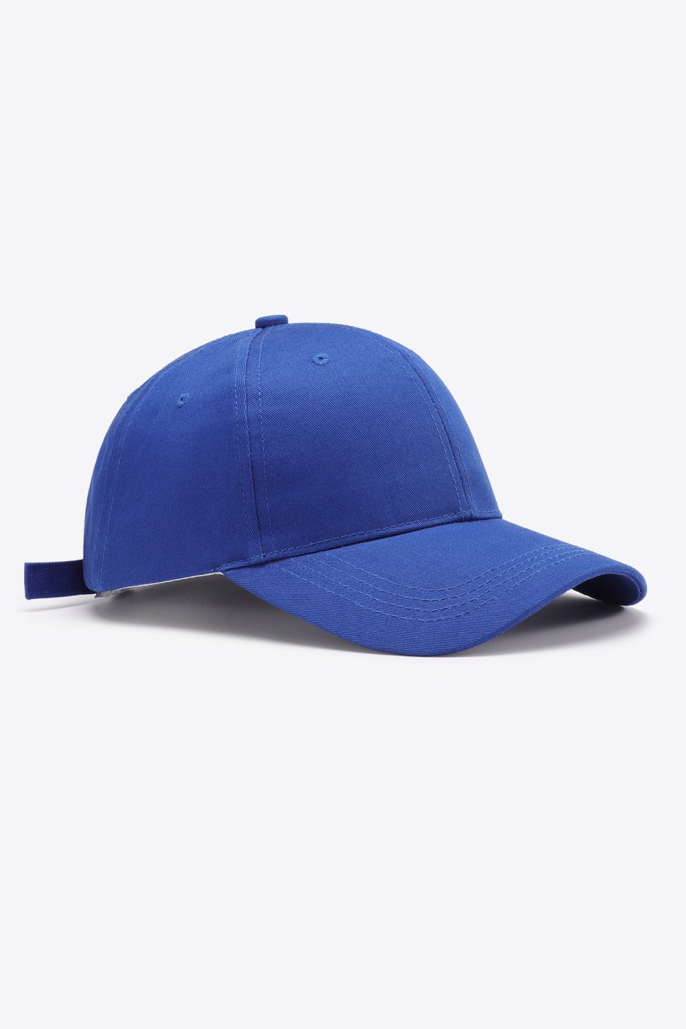 Solid blue cotton baseball cap with a structured six-panel crown, gently curved brim, tonal stitching, ventilation eyelets, and an adjustable back strap.