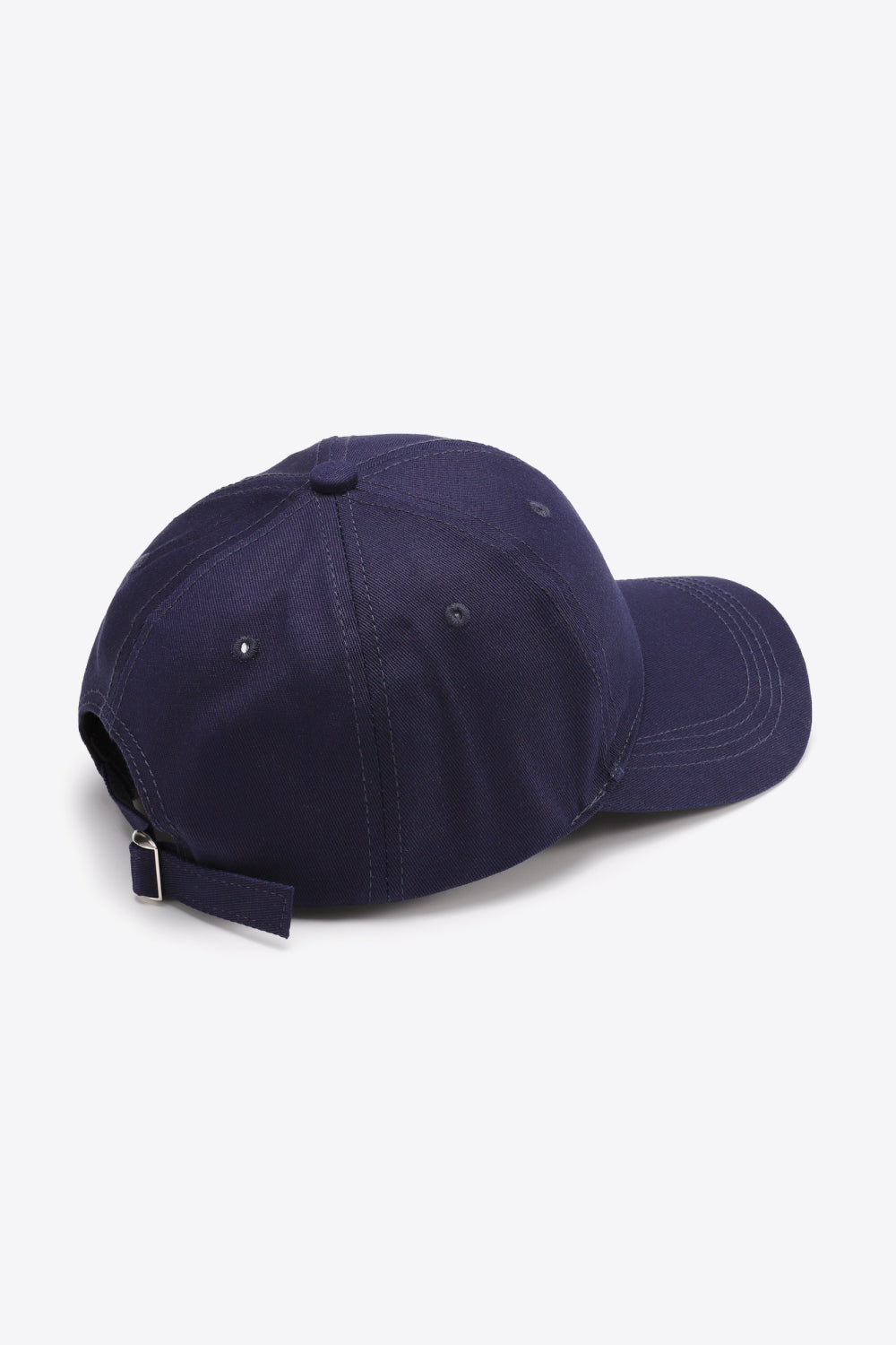Navy cotton baseball cap shown from the back and side, featuring a structured six-panel crown, curved brim, ventilation eyelets, tonal stitching, and an adjustable metal-buckle strap.