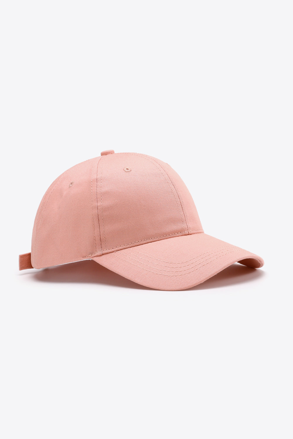 Solid pink cotton baseball cap with a structured six-panel crown, curved brim, tonal stitching, ventilation eyelets, and an adjustable back strap.