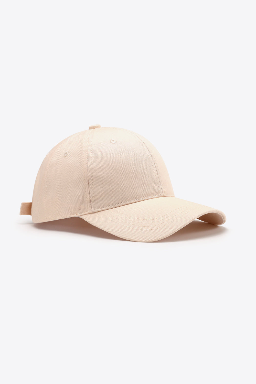 Solid beige cotton baseball cap with a structured six-panel crown, gently curved brim, tonal stitching, ventilation eyelets, and an adjustable back strap.