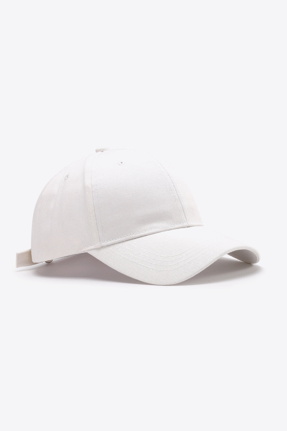 White plain cotton baseball cap with a structured six-panel crown, gently curved brim, tonal stitching, ventilation eyelets, and an adjustable back strap.