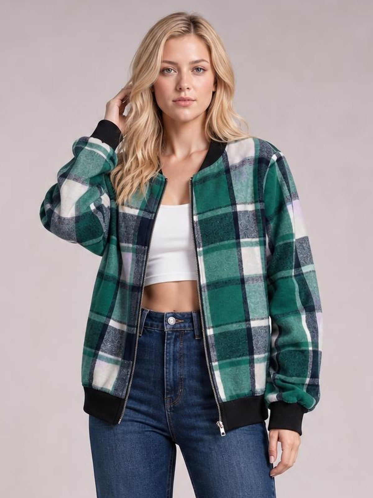 Model poses in a green, black, and white plaid baseball collar zip-up jacket with a relaxed silhouette, ribbed cuffs and hem, and front zipper.