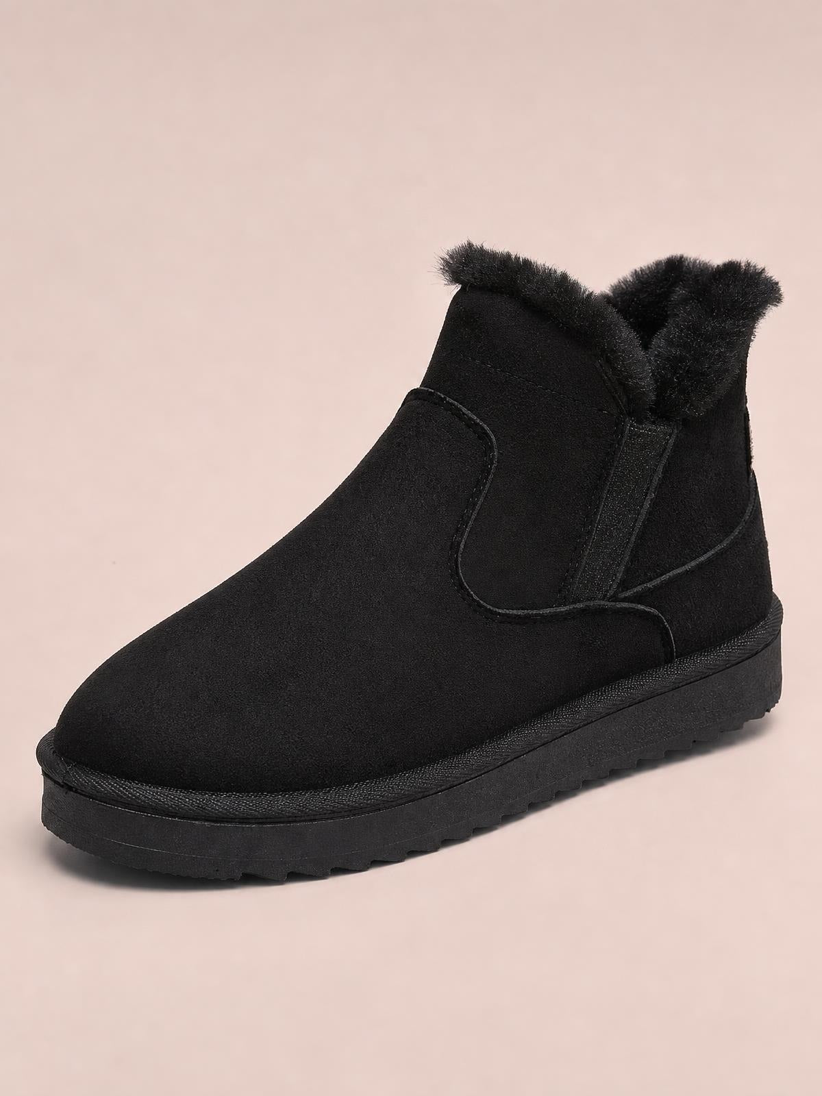 Black suede ankle boots feature plush lining at the collar, elastic side panels, rounded toes, and sturdy flat rubber lug soles.