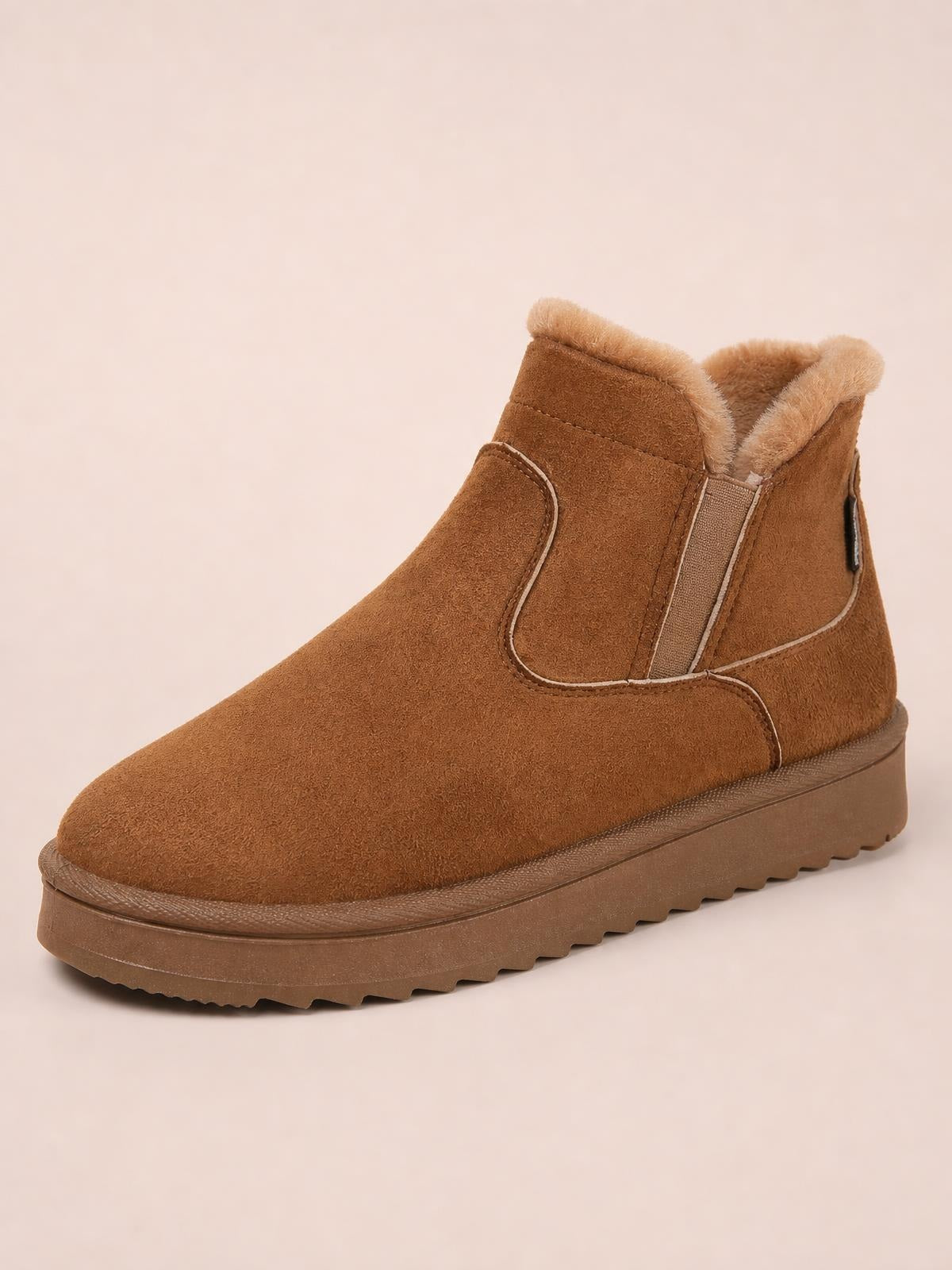 Brown suede winter ankle boot with plush lining, stitched panel construction, rounded toe, flat profile, and a sturdy rubber lug sole.