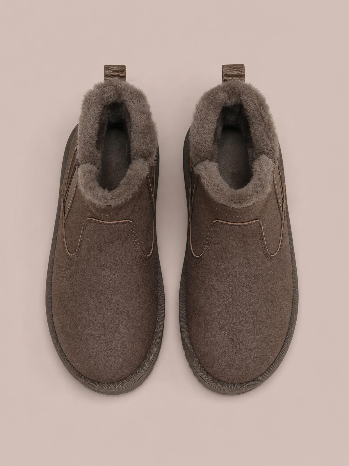 Pair of brown suede winter ankle boots with plush lining, rounded toes, rear pull tabs, stitched panels, and flat rubber soles.
