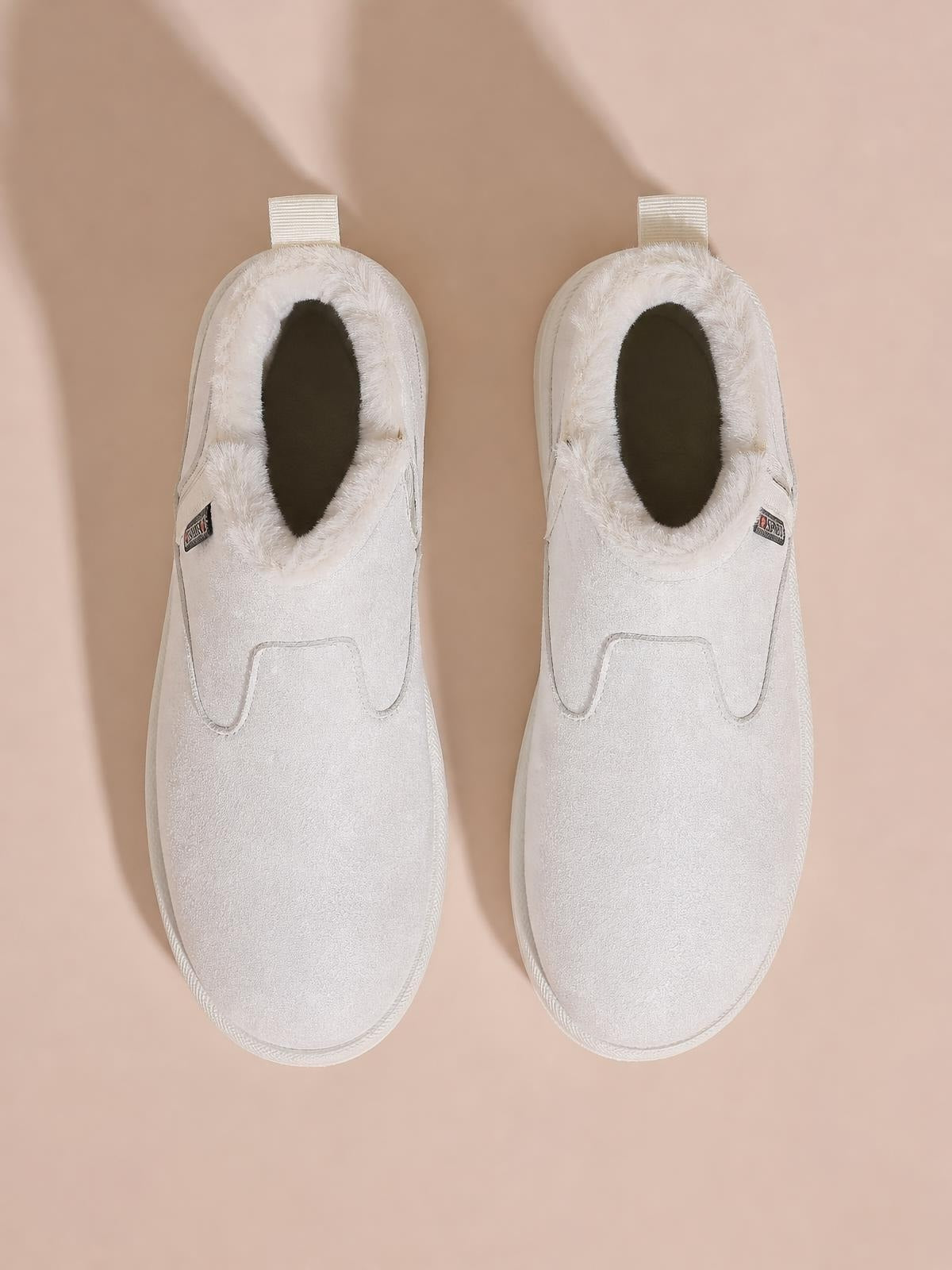 White suede winter ankle boots feature plush lining, rounded toes, slip-on construction, rear pull tabs, and flat rubber soles.