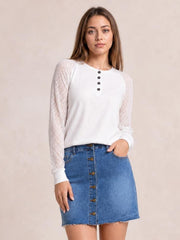 Model wearing a blue denim mini skirt with front button closure, functional pockets, straight silhouette, and raw frayed hem.