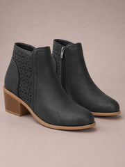 Black PU leather ankle boots with pointed toes, mid block heels, side zippers, and perforated panels for a sleek structured silhouette.