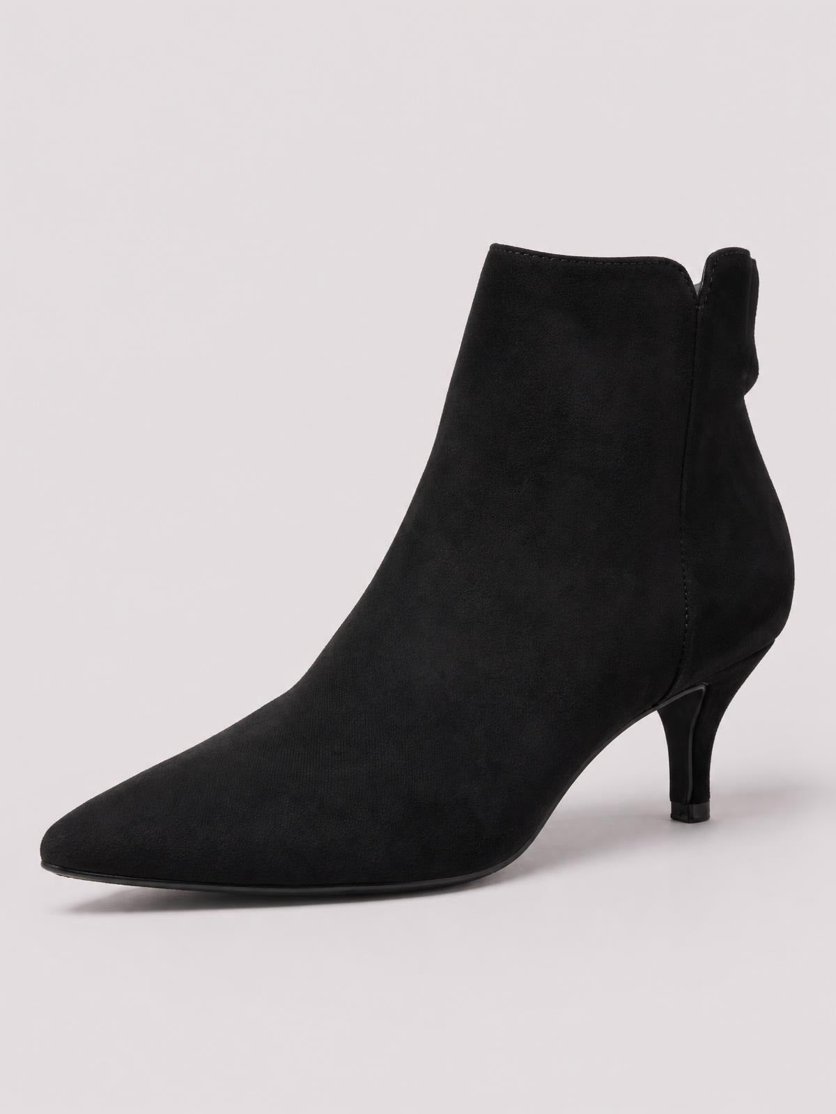 A black suede ankle boot features a sleek pointed toe, streamlined ankle silhouette, visible side seam, and a slender kitten heel.