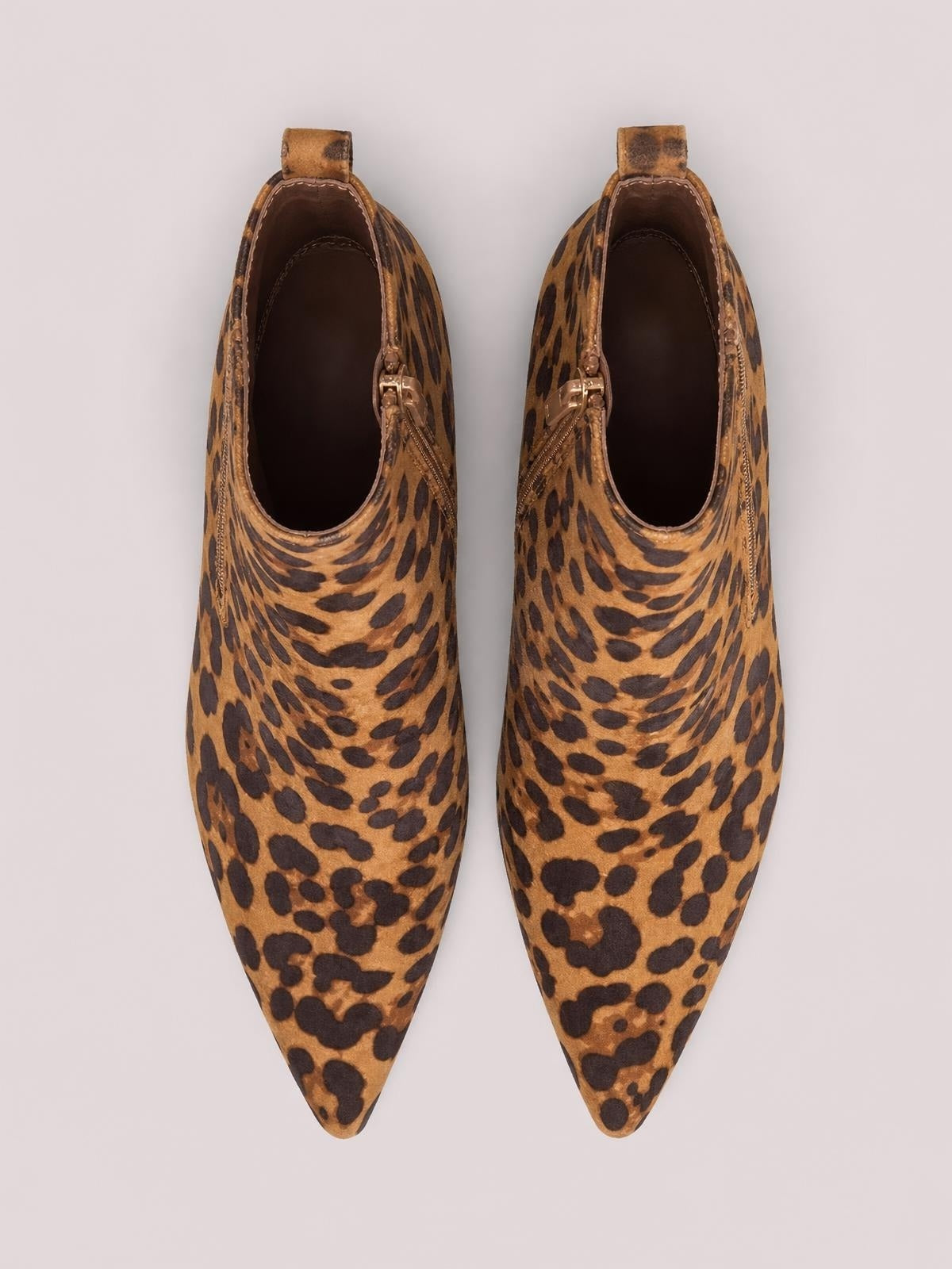 Pair of leopard-print ankle boots in a brown suede finish, featuring pointed toes, side zippers, stitched edging, and pull tabs.