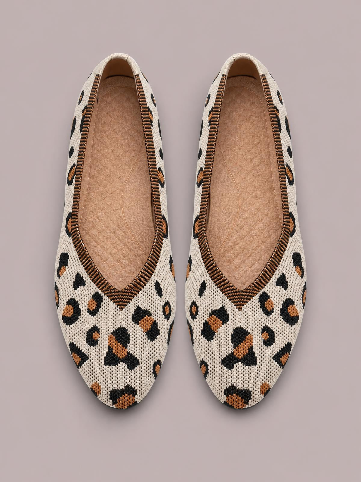 Point-toe mesh flat slip-ons in cream with black and tan leopard print, featuring open slip-on construction and textured rubber soles.
