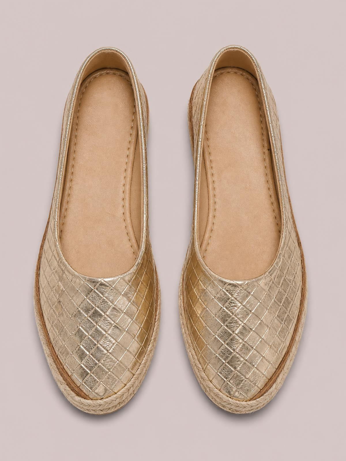 Pair of metallic gold point-toe wedge loafers with low heels, quilted textured uppers, tan insoles, and braided trim around the soles.