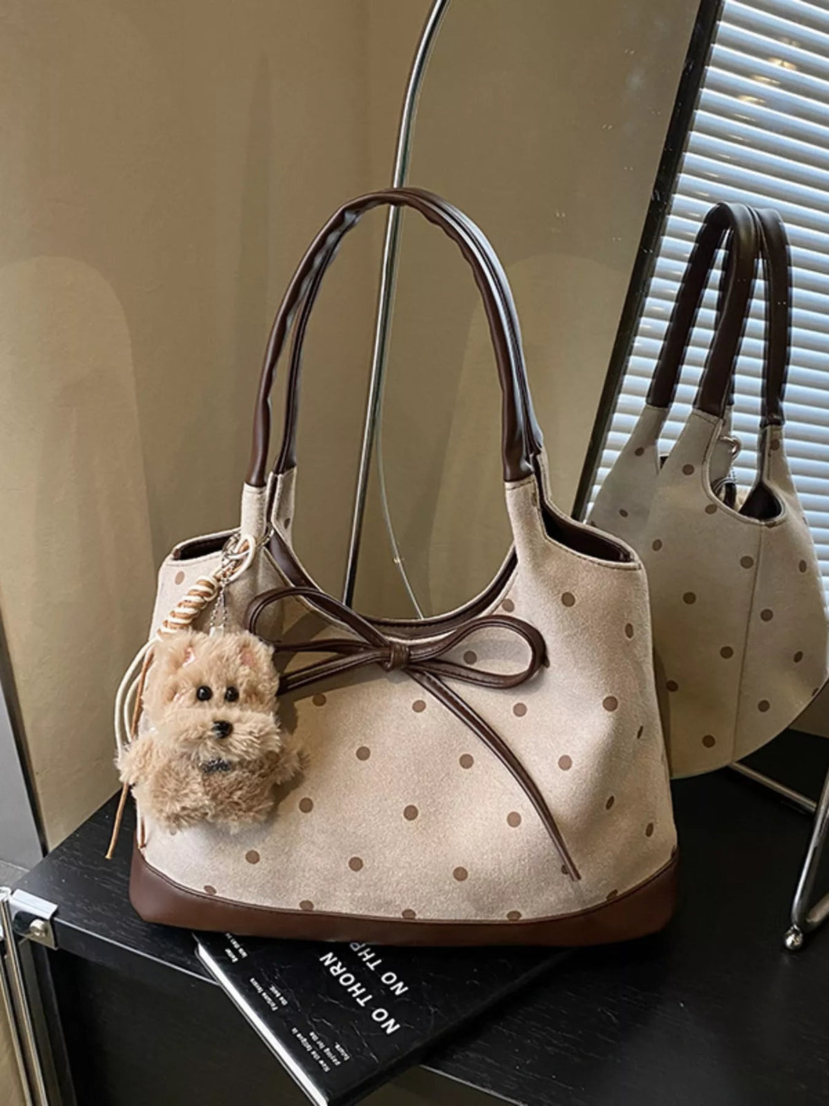 Medium cream PU leather shoulder bag with brown polka dots, contrasting trim, dual handles, and a large bow detail across the front.