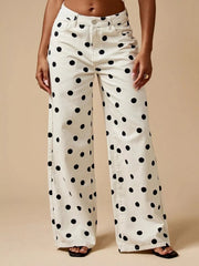 Model wearing white polka dot wide-leg jeans with a high waist, button fly, belt loops, front pockets, and a relaxed full-length silhouette.