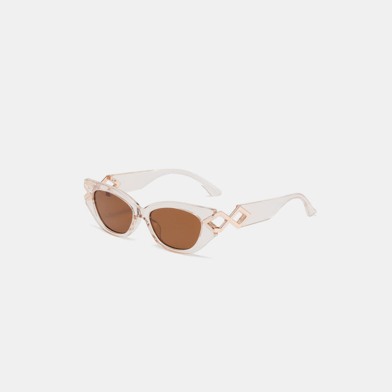 Transparent polycarbonate cat-eye sunglasses with brown lenses, upswept frames, a sleek bridge, and sculptural geometric temple details.