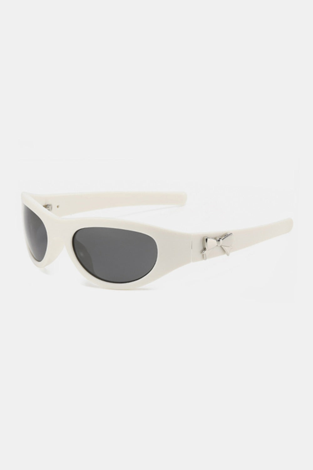 Ivory polycarbonate cat-eye sunglasses feature dark rounded lenses, a softly upswept silhouette, sculpted frame, tapered temples, and bow-shaped side detailing.