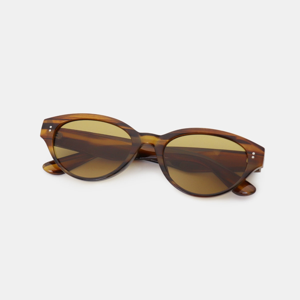 Brown tortoiseshell-style polycarbonate cat-eye sunglasses feature rounded, softly upswept frames, warm tinted lenses, and slender temples.