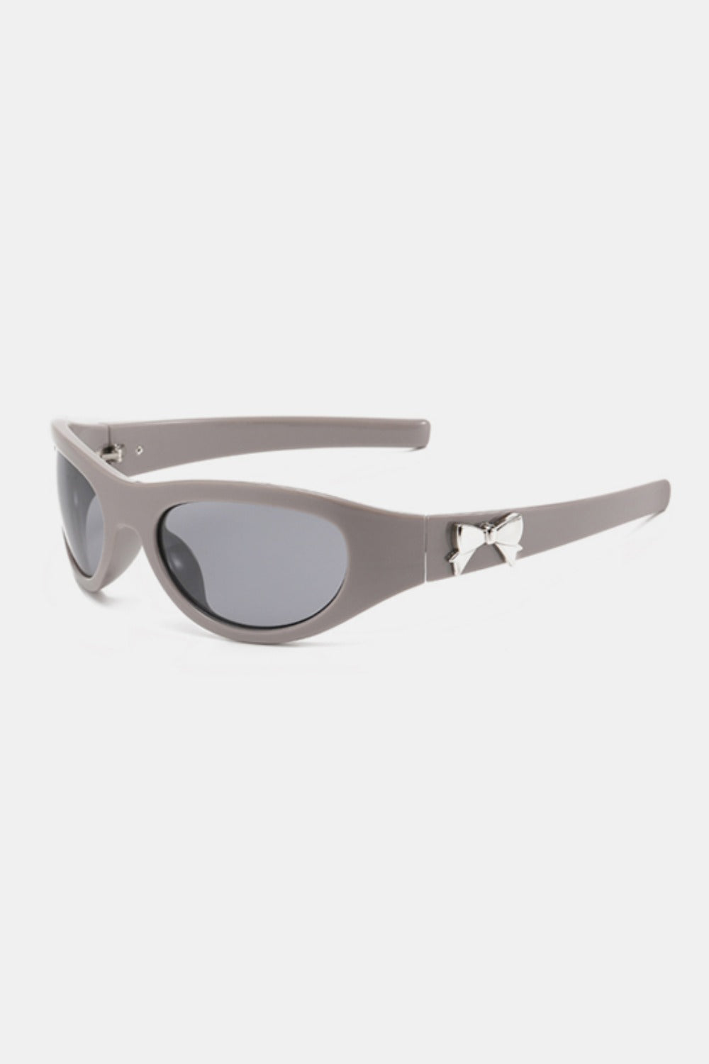 Taupe polycarbonate cat-eye sunglasses feature rounded gray lenses, softly upswept corners, tapered temples, and polished bow-shaped side detailing.